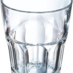 Clear glass tumbler on a white background with light reflections and beveled sides.