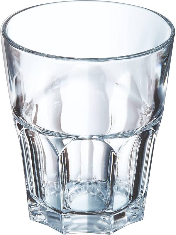 Clear glass tumbler on a white background with light reflections and beveled sides.